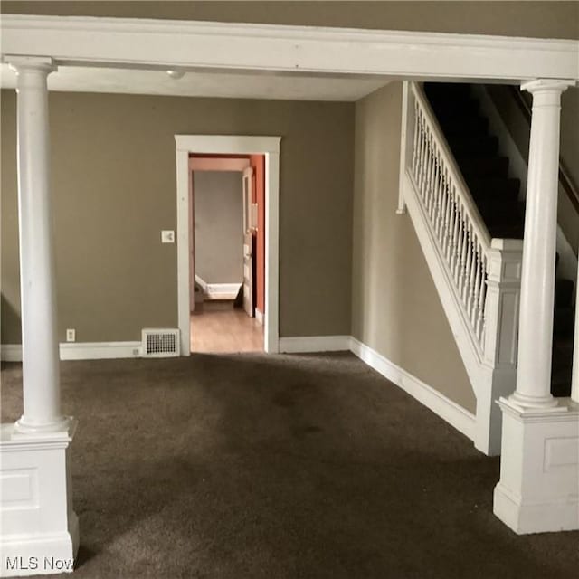 interior space with carpet, visible vents, baseboards, decorative columns, and stairs