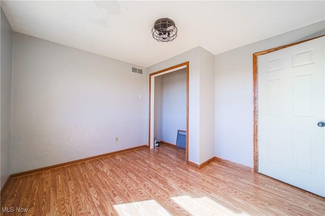 unfurnished bedroom featuring visible vents, light wood-type flooring, and baseboards