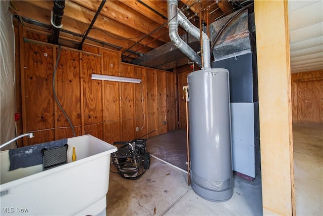 unfinished below grade area featuring gas water heater, wood walls, and a sink