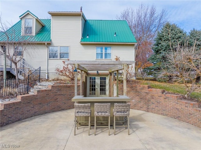 rear view of house featuring metal roof, a patio, and a pergola