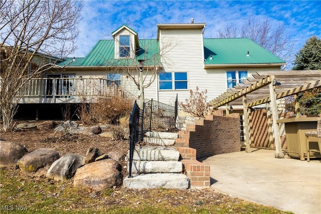 rear view of property with stairs, a patio area, a pergola, and metal roof