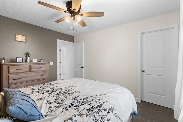 bedroom with a ceiling fan and dark carpet