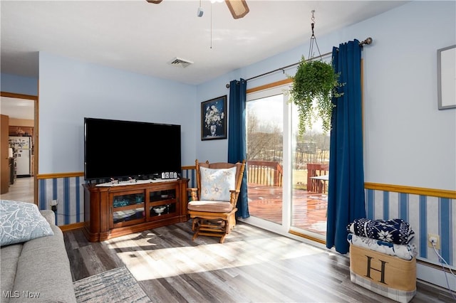 living area featuring ceiling fan, visible vents, and wood finished floors