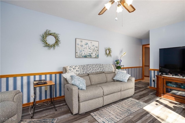 living room featuring a ceiling fan, baseboards, and wood finished floors