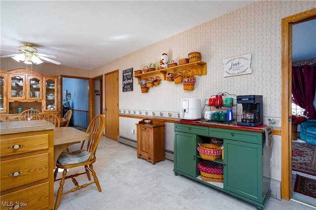 kitchen featuring baseboard heating, wallpapered walls, ceiling fan, and green cabinetry