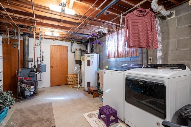 washroom featuring laundry area, water heater, a heating unit, and washing machine and clothes dryer