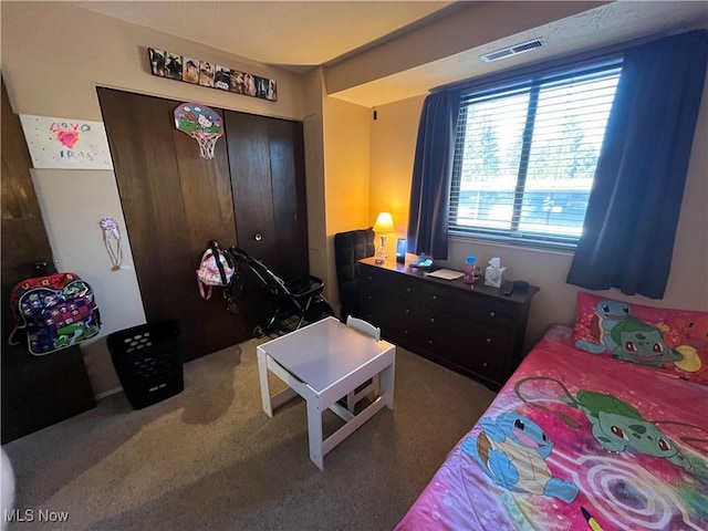 bedroom featuring a closet, visible vents, and carpet