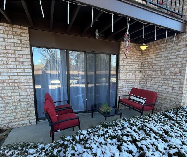 snow covered patio with a balcony