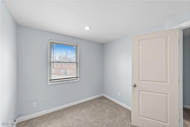 empty room featuring baseboards and carpet flooring