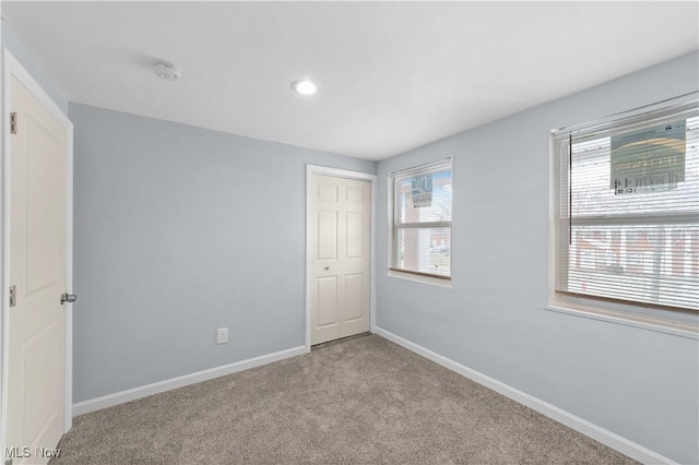 unfurnished bedroom with recessed lighting, a closet, baseboards, and carpet