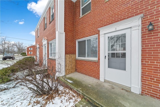 entrance to property featuring brick siding