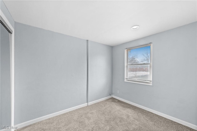 unfurnished room with baseboards and carpet