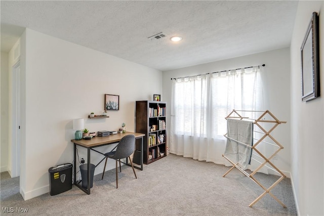 home office with visible vents, baseboards, a textured ceiling, and carpet flooring