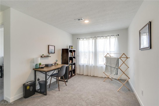 office area with carpet flooring, a textured ceiling, and baseboards