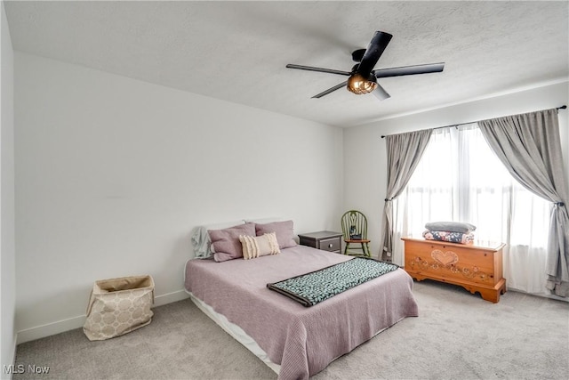 carpeted bedroom with baseboards, a textured ceiling, and ceiling fan