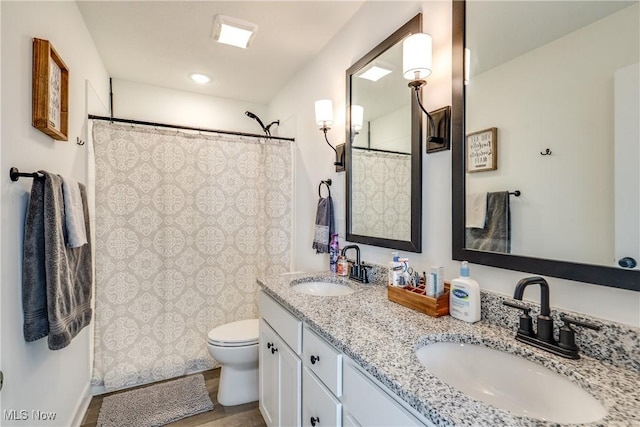 full bath with double vanity, toilet, a shower with shower curtain, and a sink