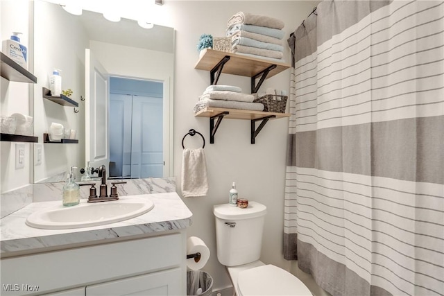 full bath featuring curtained shower, toilet, and vanity