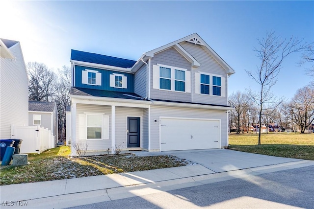 traditional home with concrete driveway, fence, a garage, and a front yard