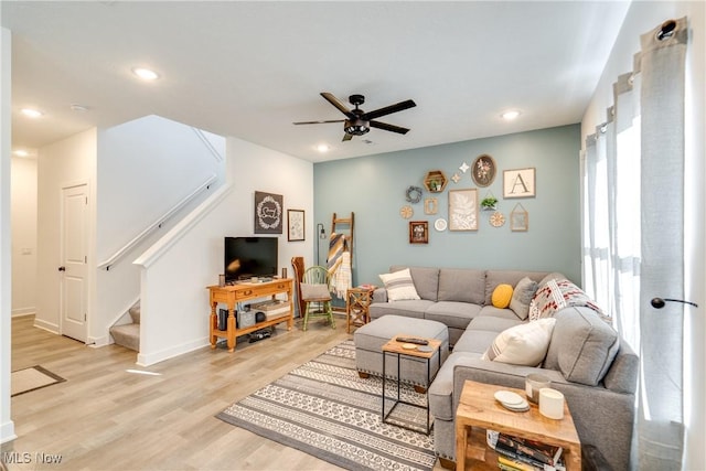 living area with a ceiling fan, baseboards, recessed lighting, stairs, and light wood-type flooring