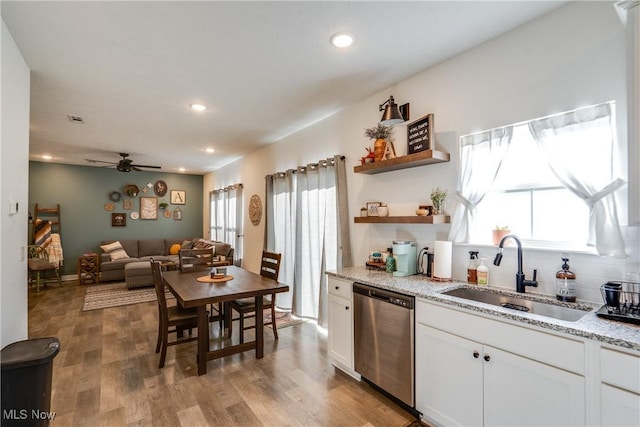 kitchen with dishwasher, light wood-type flooring, white cabinetry, and a sink