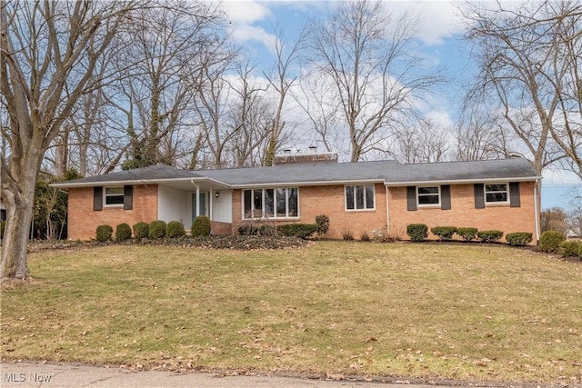 ranch-style house with brick siding, a chimney, and a front lawn