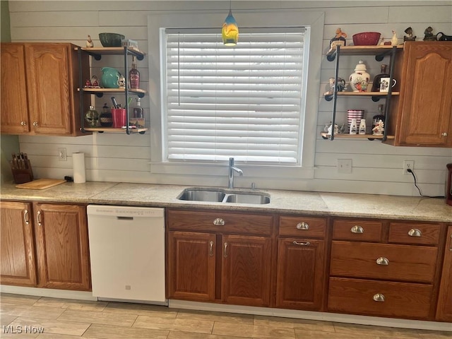 kitchen featuring open shelves, light countertops, white dishwasher, and a sink