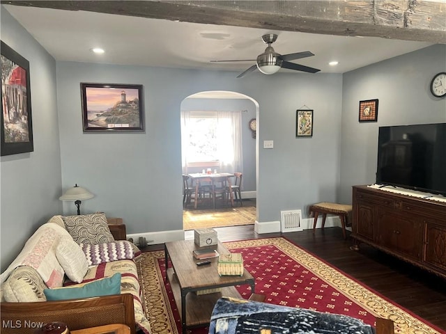 living room featuring ceiling fan, baseboards, arched walkways, and wood finished floors