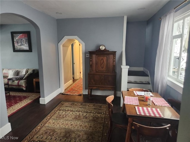 sitting room with arched walkways, baseboards, and wood finished floors