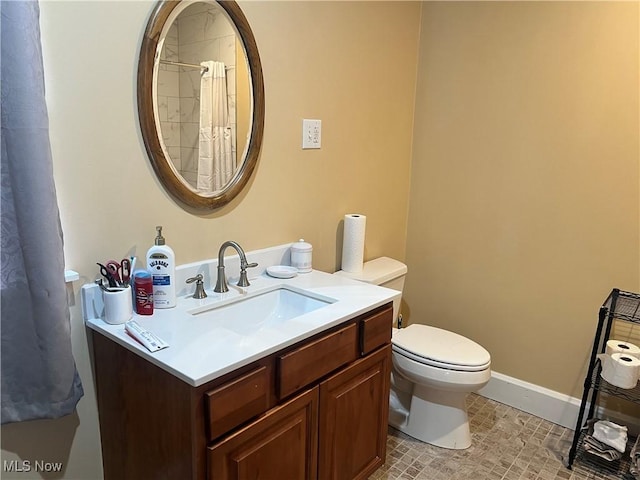 bathroom with vanity, toilet, and baseboards