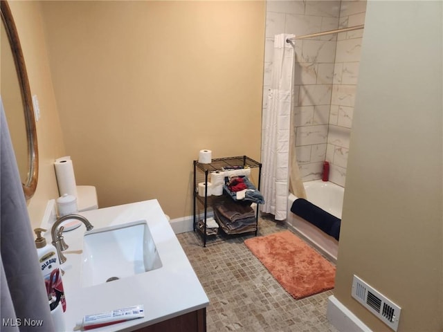 bathroom featuring visible vents, shower / bath combo with shower curtain, baseboards, and vanity