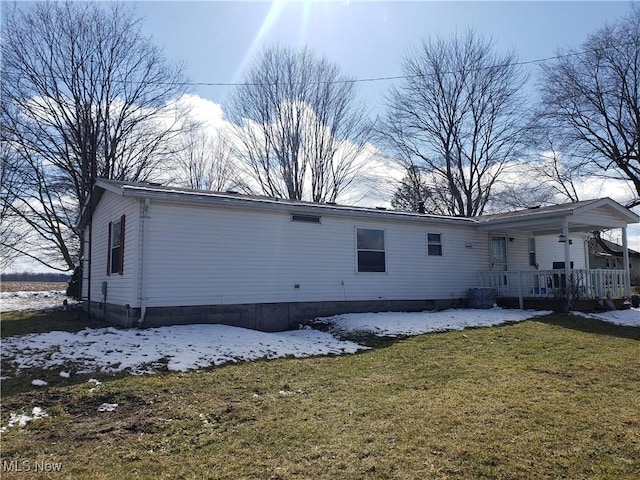 snow covered property featuring a yard and a porch