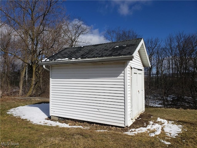 snow covered structure with an outbuilding and a shed