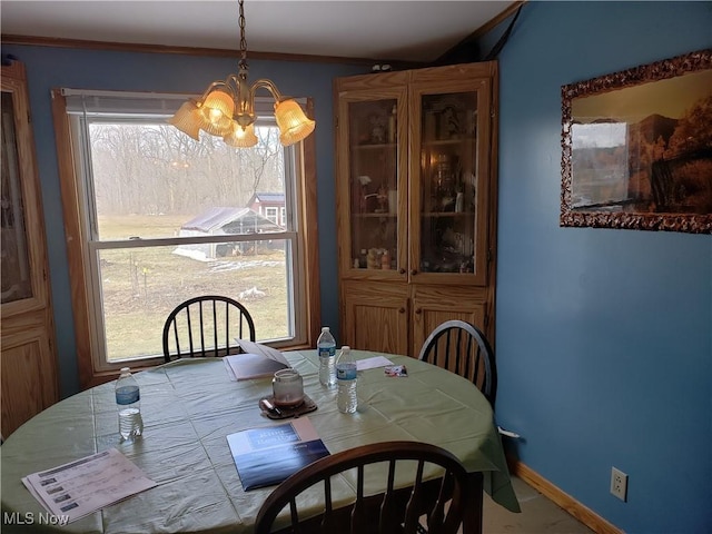 dining room with baseboards, an inviting chandelier, and crown molding