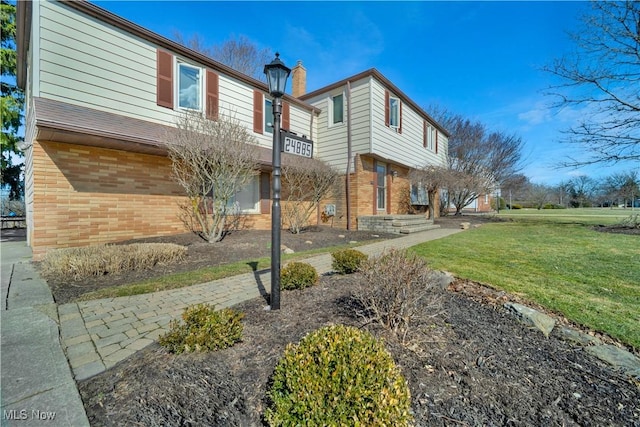 view of side of home with a lawn and brick siding