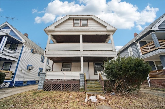 view of front of property featuring a balcony, covered porch, and a wall mounted AC