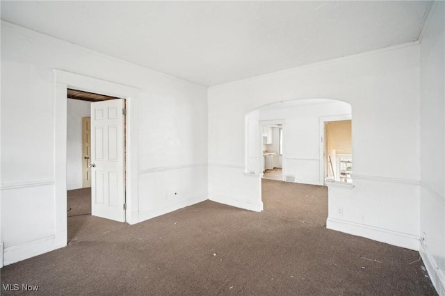 spare room with carpet flooring and arched walkways