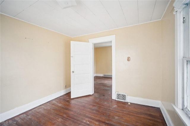 unfurnished room with visible vents, baseboards, and wood finished floors