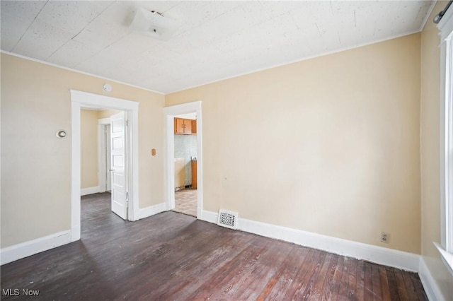 unfurnished room featuring visible vents, baseboards, and wood finished floors