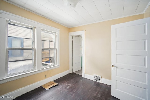 unfurnished room featuring visible vents, baseboards, dark wood-style floors, and crown molding