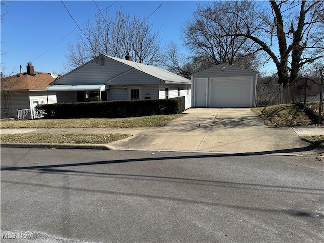 view of front of home with a garage, concrete driveway, an outdoor structure, and fence