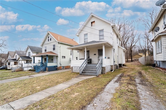 view of front facade featuring a residential view, cooling unit, a porch, and driveway