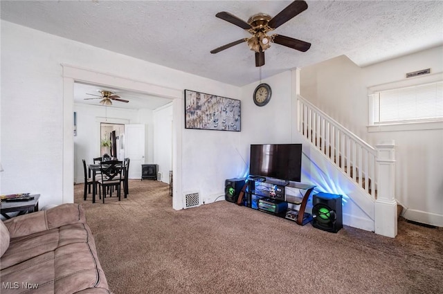 living room with stairway, carpet, visible vents, and a textured ceiling