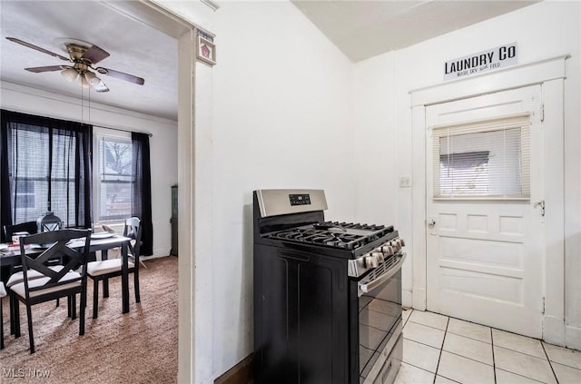 kitchen with light tile patterned floors, stainless steel gas stove, and a ceiling fan
