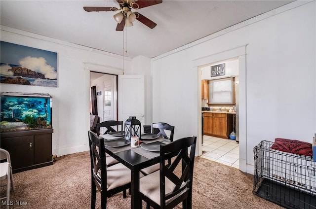 dining area with light carpet and a ceiling fan
