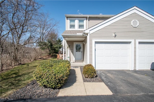 traditional home featuring aphalt driveway and a garage