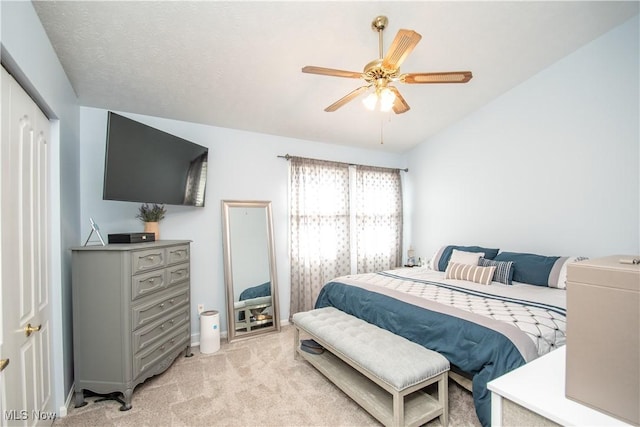 bedroom featuring a ceiling fan, vaulted ceiling, and light colored carpet