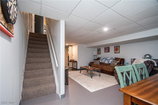 interior space with stairway, concrete flooring, and a drop ceiling