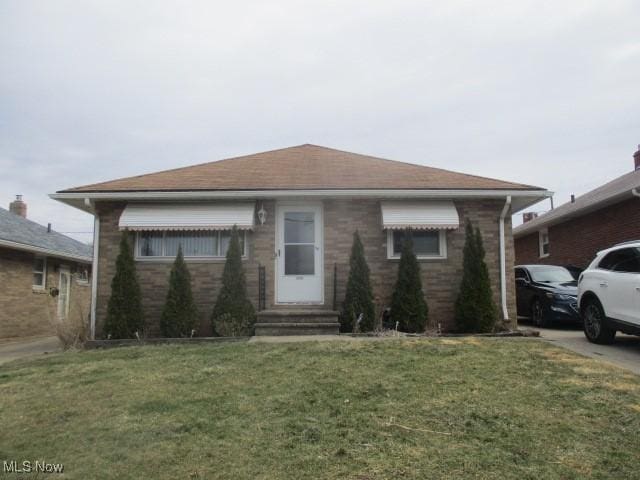 view of front of property featuring entry steps and a front lawn