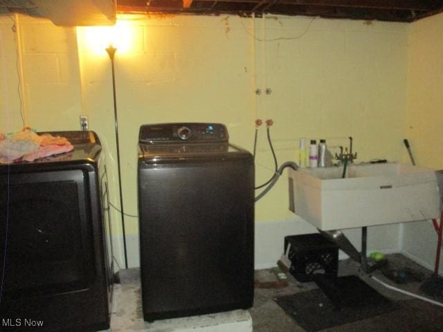 laundry area featuring a sink, laundry area, and washer / dryer