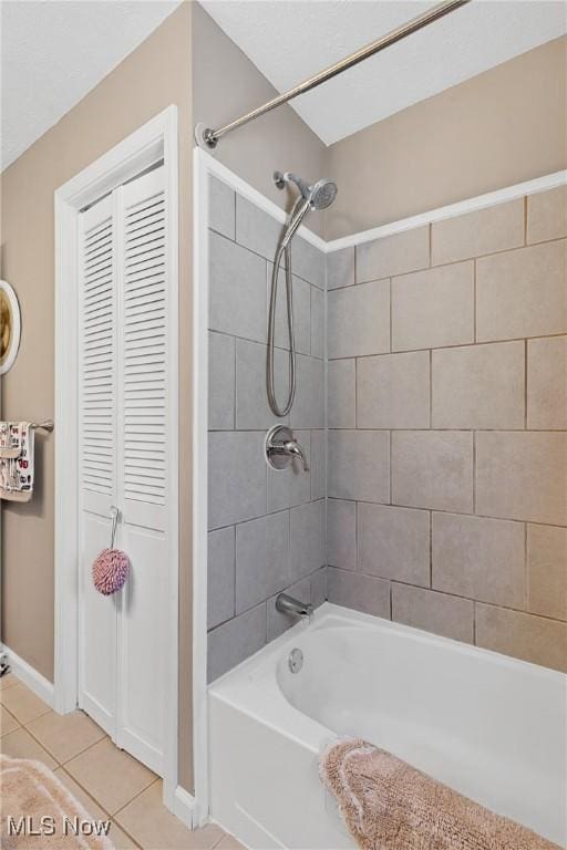 bathroom featuring tile patterned floors, a closet, washtub / shower combination, and baseboards